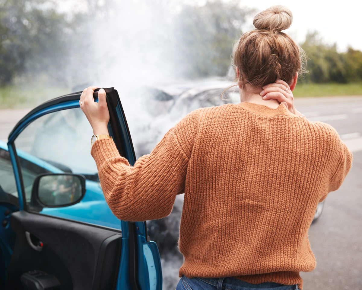 A car accident victim experiencing neck pain after a crash, representing clients seeking an Orlando personal injury lawyer from The Main Law Firm.